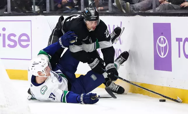 Los Angeles Kings left wing Kevin Fiala, right, trips over Vancouver Canucks defenseman Tyler Myers (57) during the second period of an NHL hockey game, Saturday, Nov. 29, 2025, in Los Angeles. (AP Photo/Jessie Alcheh)