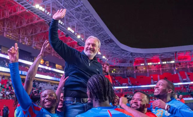 Congo national team members celebrate with their coach Sebastien Desabre after being qualified for the FIFA 2026 soccer World Cup in the African qualifier final match against Nigeria, in Rabat, Morocco, Sunday, Nov. 16, 2025. (AP Photo)