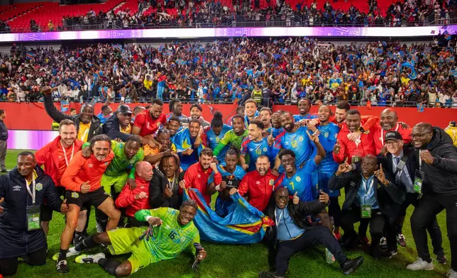 Congo national team members pose for a photo as they celebrate with their coach Sebastien Desabre after being qualified for the FIFA 2026 soccer World Cup in the African qualifier final match against Nigeria, in Rabat, Morocco, Sunday, Nov. 16, 2025. (AP Photo)