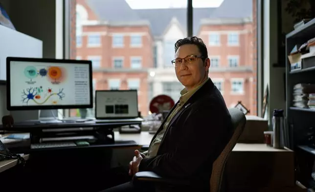 Biomedical engineer Jordan Green sits for a photo in his office at Johns Hopkins University, Tuesday, May 13, 2025, in Baltimore, Md., where his team is crafting a way for the immune system to reprogram itself with the help of instructions delivered by messenger RNA, or mRNA, the genetic code used in COVID-19 vaccines. (AP Photo/David Goldman)