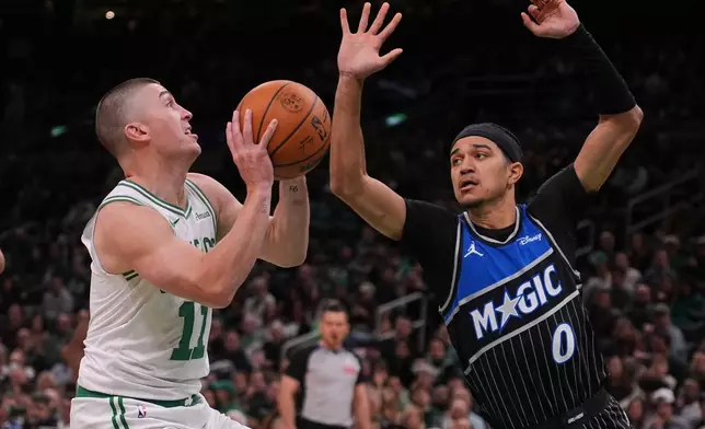 Boston Celtics guard Payton Pritchard (11) drives to the basket against Orlando Magic guard Anthony Black (0) during the first half of an NBA basketball game, Sunday, Nov. 23, 2025, in Boston. (AP Photo/Charles Krupa)