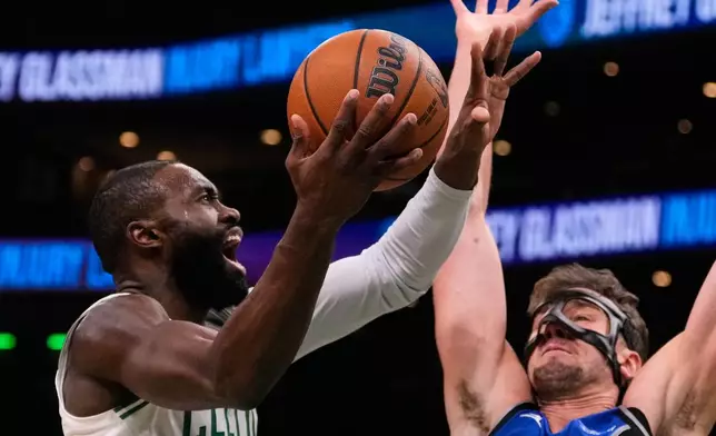 Boston Celtics guard Jaylen Brown, left, drives to the basket against Orlando Magic forward Franz Wagner during the first half of an NBA basketball game, Sunday, Nov. 23, 2025, in Boston. (AP Photo/Charles Krupa)