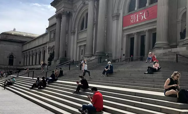 FILE - People sit outside the Metropolitan Museum of Art on May 2, 2020 in New York. (AP Photo/Ron Blum, file)