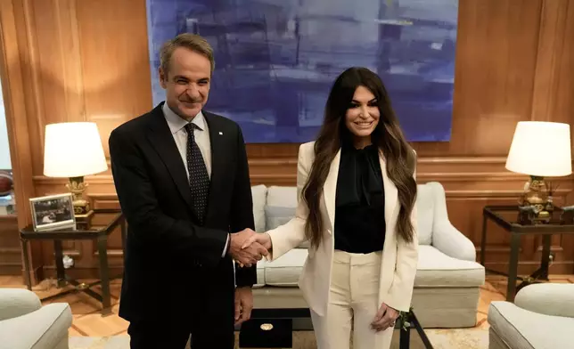 Greece's Prime Minister Kyriakos Mitsotakis, left, welcomes Kimberly Guilfoyle, the new U.S. Ambassador to Greece, at Maximos Mansion in Athens, Greece, Wednesday, Nov. 5, 2025. (AP Photo/Thanassis Stavrakis)