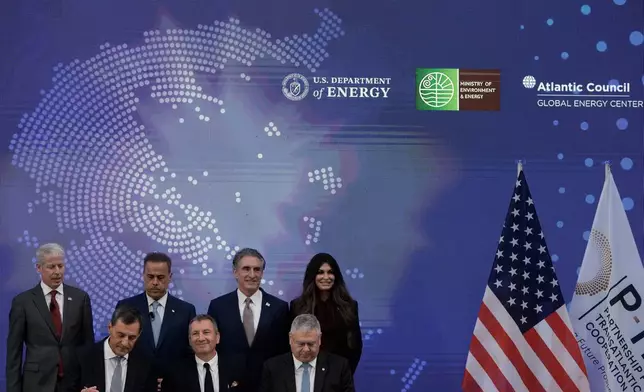 Chris Wright, Secretary of the U.S. Department of Energy, top left, Stavros Papastavrou, Greek Minister for Environment and Energy, top second left, Doug Burgum, U.S. Secretary of the Interior, top second right, and Kimberly Guilfoyle, U.S. Ambassador to Greece, top right, attend a signing ceremony from executives of Exxon Mobil, and Greek energy firms Helleniq Energy and Energean, during the Atlantic Council conference, in Athens, Greece, Thursday, Nov. 6, 2025. (AP Photo/Thanassis Stavrakis)