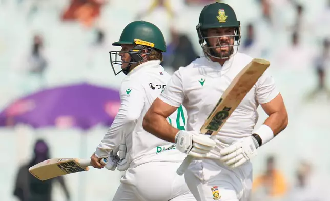 South Africa's Ryan Rickelton, left, and batting partner Aiden Markram run between the wickets to score on the first day of the first cricket test match between India and South Africa in Kolkata, India, Friday, Nov. 14, 2025. (AP Photo/Aijaz Rahi)