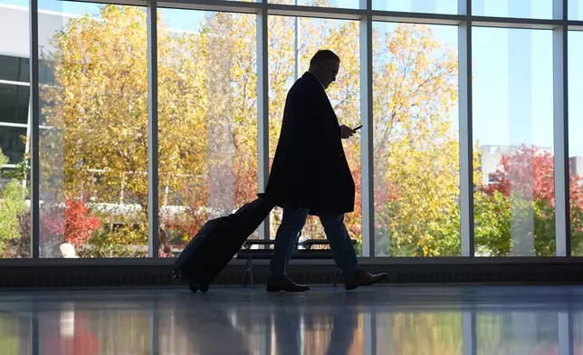 A traveler moves through a baggage claim in Philadelphia International Airport in Philadelphia, Wednesday, Nov. 5, 2025. (AP Photo/Matt Rourke)