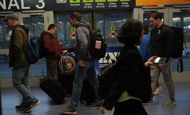 Travelers walk through the terminal at O'Hare International Airport in Chicago, Friday, Nov. 7, 2025. (AP Photo/Nam Y. Huh)