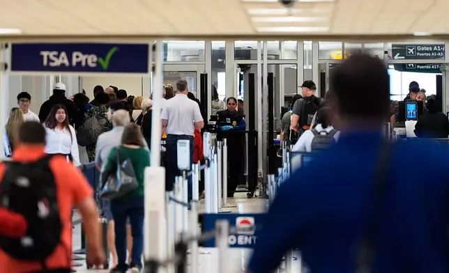 Travelers stand in line at a security checkpoint at George Bush Intercontinental Airport on Friday, Nov. 7, 2025, in Houston. (AP Photo/Ashley Landis)