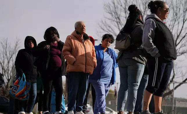 Fran Cooper, center left,, accompanied by her care giver Lily Bubjaku, waits in line durning an emergency food distribution at The Jewish Federation of Greater Philadelphia's Mitzvah Food Program in Philadelphia, Friday, Nov. 7, 2025. (AP Photo/Matt Rourke)
