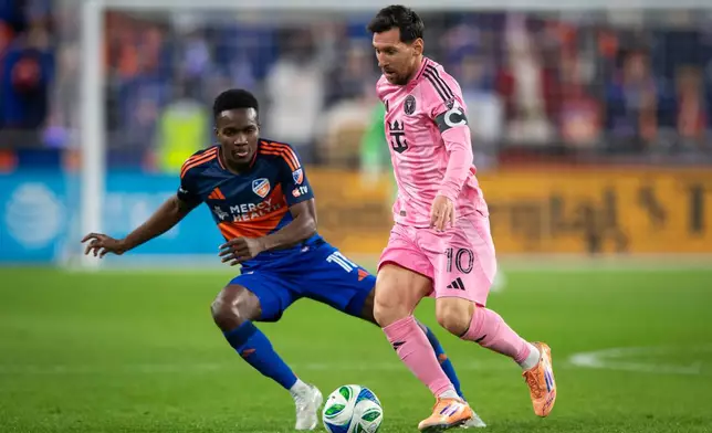 Inter Miami forward Lionel Messi (10) controls the ball as FC Cincinnati forward Corey Baird (11) defends during the first half of MLS soccer's Eastern Conference semifinal Sunday, Nov. 23, 2025, in Cincinnati. (AP Photo/Tanner Pearson)