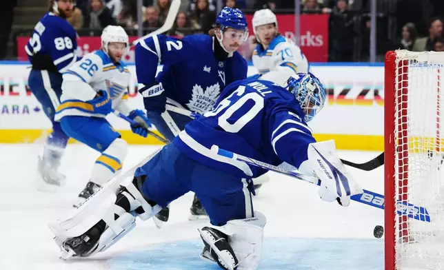 Toronto Maple Leafs goaltender Joseph Woll watches the puck go in the net on a goal by St. Louis Blues' Nathan Walker (26) as Maple Leafs' Simon Benoit (2) looks on during the first period of NHL hockey in Toronto on Tuesday, Nov. 18, 2025. (Nathan Denette/The Canadian Press via AP)