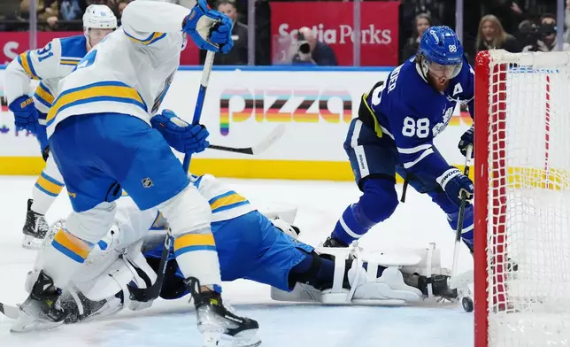 Toronto Maple Leafs' William Nylander (88) scores the game-winning goal against St. Louis Blues goaltender Jordan Binnington (50) during overtime of an NHL hockey game in Toronto on Tuesday, Nov. 18, 2025. (Nathan Denette/The Canadian Press via AP)