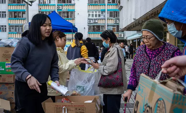 Volunteers distribute donated supplies following the fire that started Wednesday at Wang Fuk Court, a residential estate in the Tai Po district of Hong Kong's New Territories, Friday, Nov. 28 2025. (AP Photo/Chan Long Hei)
