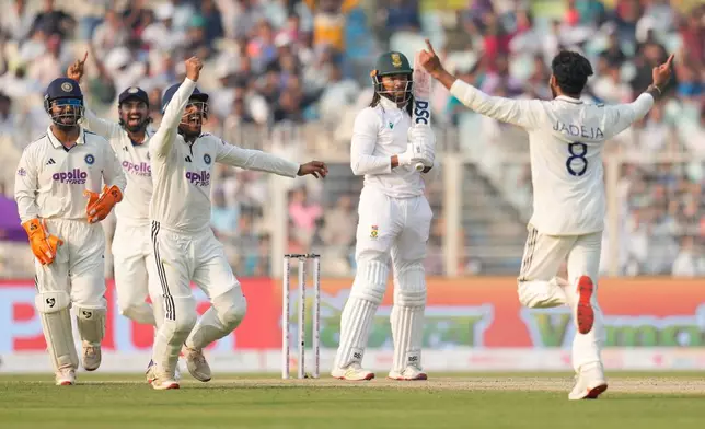 India's Ravindra Jadeja, right, and teammates celebrate the dismissal of South Africa's Tony de Zorzi, second right, on the second day of the first cricket test match between India and South Africa in Kolkata, India, Saturday, Nov. 15, 2025. (AP Photo/Aijaz Rahi)