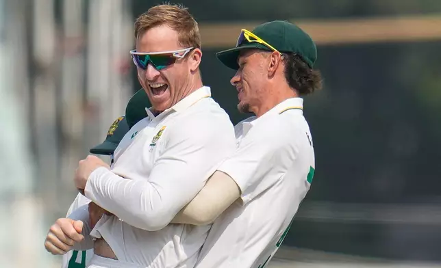 South Africa's Simon Harmer, left, celebrates with teammate Marco Jansen after the dismissal of India's Washington Sundar on the second day of the first cricket test match between India and South Africa in Kolkata, India, Saturday, Nov. 15, 2025. (AP Photo/Aijaz Rahi)