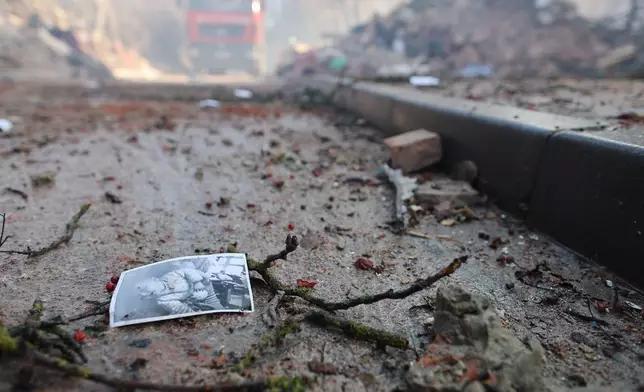 A photograph of a child lies on the ground near a residential building which was heavily damaged by a Russian strike on Ternopil, Ukraine, on Wednesday, Nov. 19, 2025. (AP Photo/Vlad Kravchuk)