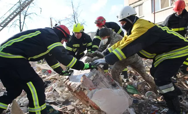 Rescue workers clear the rubble of a residential building which was heavily damaged by a Russian strike on Ternopil, Ukraine, on Wednesday, Nov. 19, 2025. (AP Photo/Vlad Kravchuk)