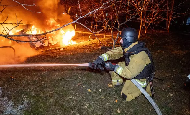 Rescue workers put out a fire of a residential building damaged by a Russian strike on Kharkiv, Ukraine, Wednesday, Nov. 19, 2025. (AP Photo/Andrii Marienko)