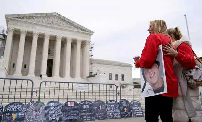 FILE - Jen Trejo holds a photo of her son Christopher as she is comforted outside the Supreme Court Dec. 4, 2023, in Washington. (AP Photo/Stephanie Scarbrough, File)