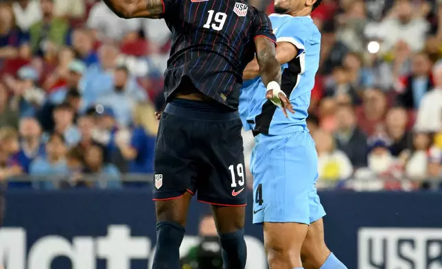 United States's Haji Wright (19) and Uruguay Ronald Araujo go up for a header during the first half of an international friendly soccer game, Tuesday, Nov. 18, 2025, in Tampa, Fla. (AP Photo/Jason Behnken)