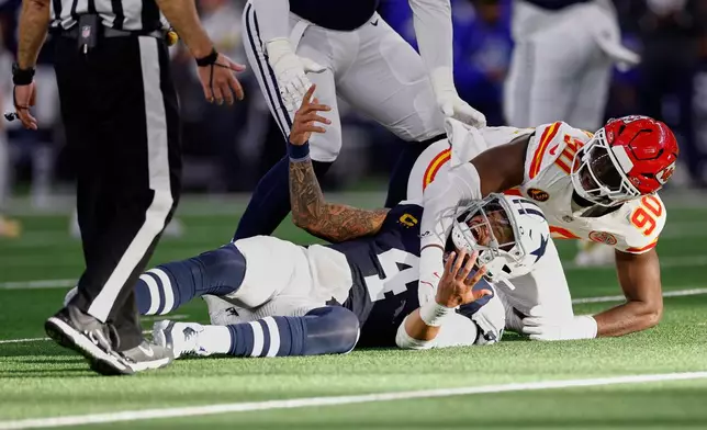 Dallas Cowboys quarterback Dak Prescott (4) reacts after being brought down by Kansas City Chiefs defensive end Charles Omenihu (90) during the first half of an NFL football game Thursday, Nov. 27, 2025, in Arlington, Texas. (AP Photo/Gareth Patterson)