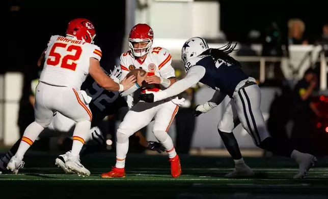 Kansas City Chiefs quarterback Patrick Mahomes (15) is sacked by Dallas Cowboys defensive end Jadeveon Clowney, right, as Chiefs center Creed Humphrey (52) watches during the first half of an NFL football game Thursday, Nov. 27, 2025, in Arlington, Texas. (AP Photo/Gareth Patterson)