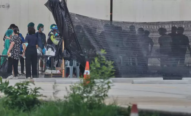 Forensic officers inspect recovered dead bodies from floodwaters in Songkhla province, southern Thailand, Friday, Nov. 28, 2025. (AP Photo/Sarot Meksophawannakul)