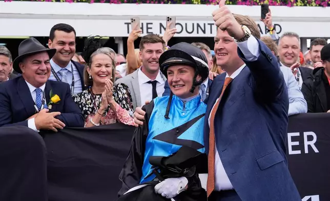 Trainer Calvin McEvoy and jockey Jamie Melham celebrate after Half Yours won the Melbourne Cup horse race in Melbourne, Australia, Tuesday, Nov. 4, 2025. (AP Photo/Asanka Brendon Ratnayake)