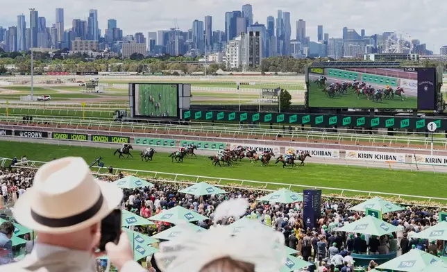 Spectators watch a race ahead of the Melbourne Cup horse race in Melbourne, Australia, Tuesday, Nov. 4, 2025. (AP Photo/Asanka Brendon Ratnayake)