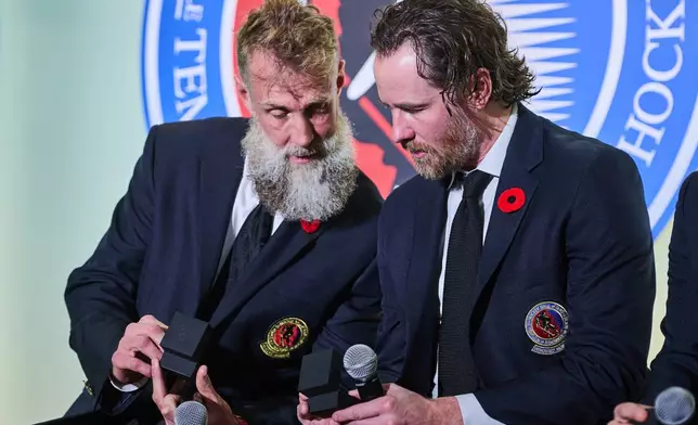 Hockey Hall of Fame inductees Joe Thornton, left, and Duncan Keith look at their rings in Toronto on Saturday, Nov. 8, 2025. (Sammy Kogan/The Canadian Press via AP)