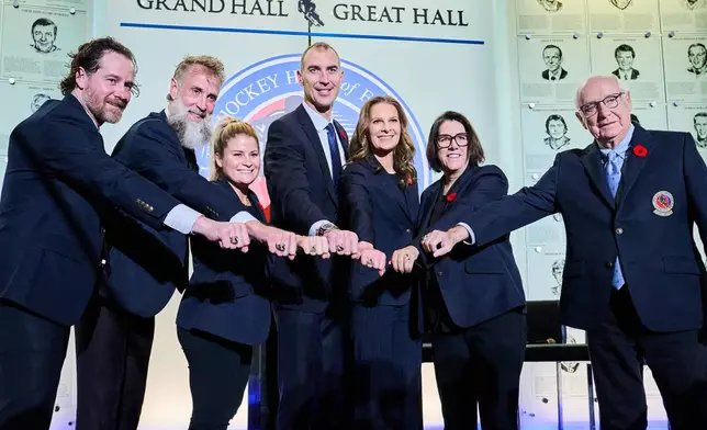 Hockey Hall of Fame inductees, from left, Duncan Keith, Joe Thornton, Brianna Decker, Zdeno Chara, Jennifer Botterill, Danièle Sauvageau and Jack Parker pose for a photograph in Toronto, Saturday, Nov. 8, 2025. (Sammy Kogan/The Canadian Press via AP)