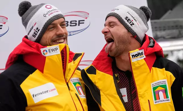 Johannes Lochner and Georg Fleischhauer of Germany celebrate winning the 2-man bobsleigh, at the Bobsleigh World Cup in Innsbruck, Austria, Saturday, Nov. 29, 2025. (AP Photo/Matthias Schrader)