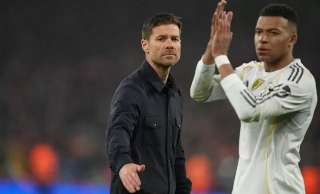 Real Madrid's head coach Xabi Alonso and Kylian Mbappe walk off the oitch after the Champions League soccer match between Liverpool and Real Madrid in Liverpool, England, Tuesday, Nov. 4, 2025. (AP Photo/Jon Super)