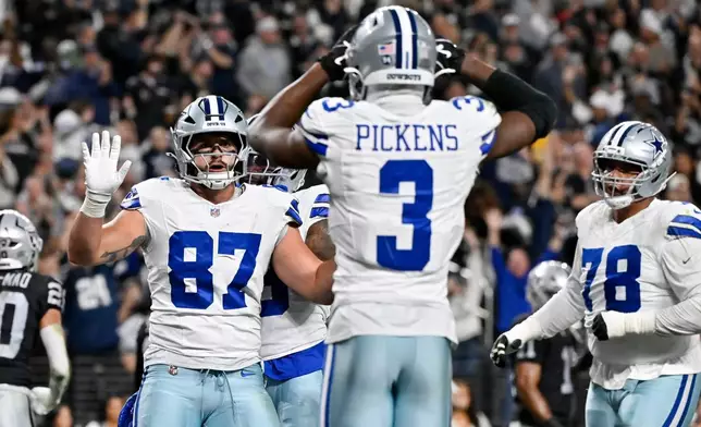 Dallas Cowboys tight end Jake Ferguson (87) celebrates his touchdown catch against the Las Vegas Raiders with Cowboys wide receiver George Pickens (3) as Cowboys offensive tackle Terence Steele (78) looks on during the first half of an NFL football game Monday, Nov. 17, 2025, in Las Vegas. (AP Photo/David Becker)