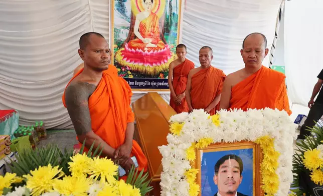 In this photo released by Agence Kampuchea Press (AKP), Cambodian Buddhist monks surround a coffin with the body of Dy Nay, killed during a clash with Thai soldiers in Prey Chan village, Banteay Meanchey province, on the border with Thailand, at Prey Chan village, Banteay Meanchey province, Cambodia, Thursday, Nov. 13, 2025 (AKP via AP)