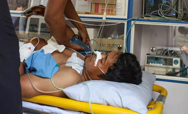 This photo released by Agence Kampuchea Press (AKP) shows an injured man on a medical emergency stretcher as he was being transported to the main hospital, in Prey Chan village, Banteay Meanchey province, a border area to Thailand, on Thursday, Nov. 13, 2025. (AKP via AP)