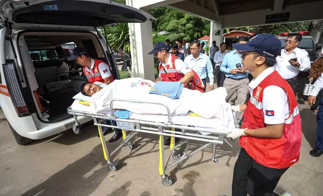 In this photo released by Agence Kampuchea Press (AKP), a man on a medical emergency stretcher is carried into an ambulance on the way to the main hospital after he was injured in Prey Chan village, Banteay Meanchey province, a border town to Thailand, on Thursday, Nov. 13, 2025 (AKP via AP)
