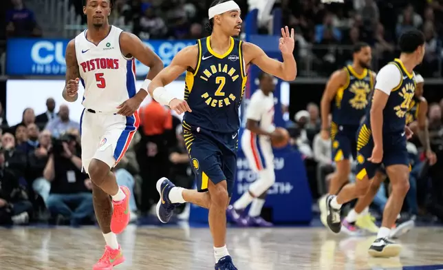 Indiana Pacers guard Andrew Nembhard (2) celebrates near Detroit Pistons forward Ronald Holland II (5) after scoring a three-point basket during the first half of an NBA basketball game Monday, Nov. 17, 2025, in Detroit. (AP Photo/Ryan Sun)