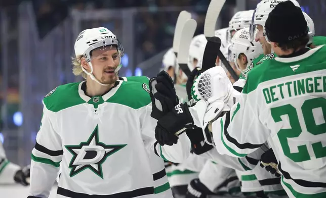 Dallas Stars center Roope Hintz (24) celebrates with the bench after scoring during the first period of an NHL hockey game against the Seattle Kraken, Wednesday, Nov. 26, 2025, in Seattle. (AP Photo/Jason Redmond)