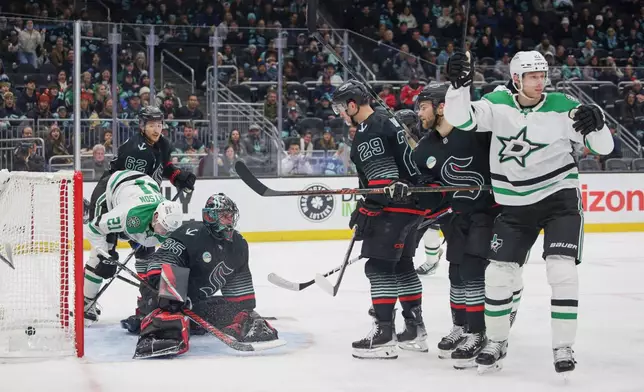 Dallas Stars defenseman Esa Lindell, right, reacts after scoring as Seattle Kraken goalie Joey Daccord (35) looks on during the second period of an NHL hockey game Wednesday, Nov. 26, 2025, in Seattle. (AP Photo/Jason Redmond)