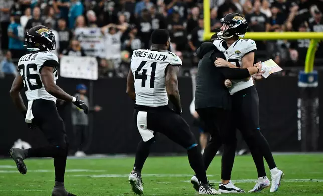 Jacksonville Jaguars place kicker Cam Little, from right, is congratulated by head coach Liam Coen after making a 68-yard field goal during the first half of an NFL football game, Sunday against the Las Vegas Raiders, Nov. 2, 2025, in Las Vegas. (AP Photo/David Becker)