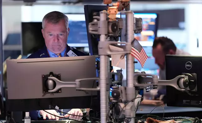 James Lamb works on the floor at the New York Stock Exchange in New York, Thursday, Nov. 13, 2025. (AP Photo/Seth Wenig)