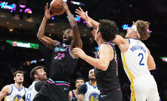 Miami Heat forward Andrew Wiggins (22) goes for a rebound as Golden State Warriors guard Brandin Podziemski (2) defends during the first half of an NBA basketball game, Wednesday, Nov. 19, 2025, in Miami. (AP Photo/Lynne Sladky)