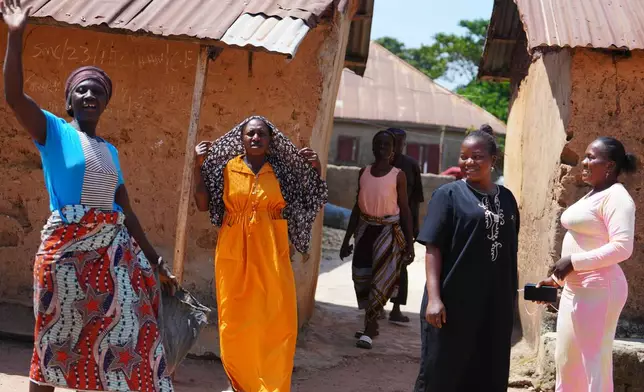 A woman and others who were kidnapped during a church service in November 2024 waves outside her house in Kaduna, northwestern Nigeria, Nov. 6, 2025. (AP Photo/Sunday Alamba)