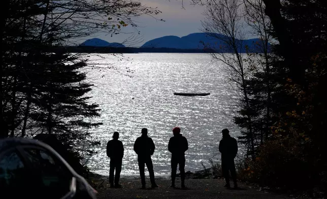 Graham Platner, Democratic candidate for U.S. Senate, third from left, and others, take in the view of Frenchman's Bay near his oyster farm, Monday, Nov. 3, 2025, in Sullivan, Maine. (AP Photo/Robert F. Bukaty)