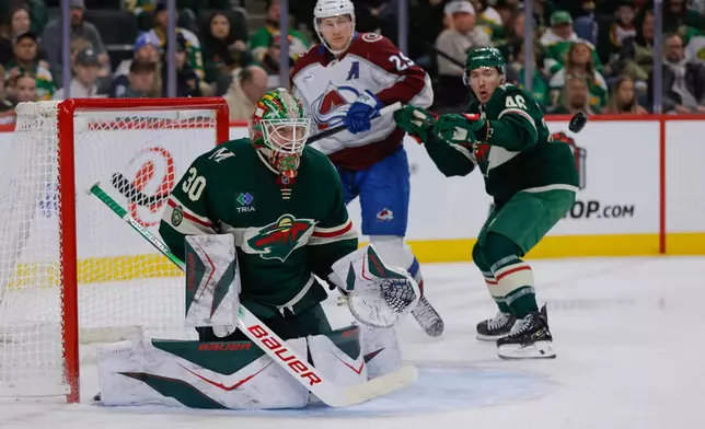 Minnesota Wild goaltender Jesper Wallstedt (30) watches the puck while defenseman Jared Spurgeon (46) defends against Colorado Avalanche center Nathan MacKinnon (29) during the second period of an NHL hockey game Friday, Nov. 28, 2025, in St. Paul, Minn. (AP Photo/Bailey Hillesheim)