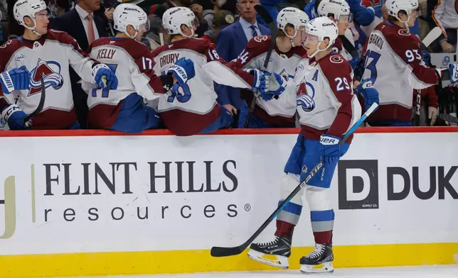 Colorado Avalanche center Nathan MacKinnon (29) is congratulated by teammates after scoring during the first period of an NHL hockey game against the Minnesota Wild, Friday, Nov. 28, 2025, in St. Paul, Minn. (AP Photo/Bailey Hillesheim)
