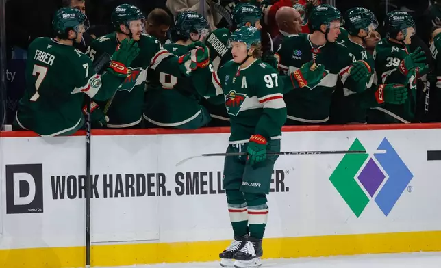 Minnesota Wild left wing Kirill Kaprizov (97) is congratulated by teammates after scoring his second goal of the game during the second period of an NHL hockey game against the Colorado Avalanche, Friday, Nov. 28, 2025, in St. Paul, Minn. (AP Photo/Bailey Hillesheim)