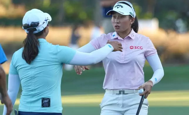Jeeno Thitikul of Thailand, right, and Sei Young Kim of South Korea talk at the end of the second round of the LPGA Tour Championship golf tournament, Friday, Nov. 21, 2025, in Naples, Fla. (AP Photo/Marta Lavandier)
